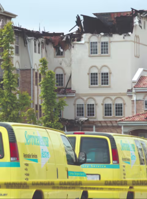 A fire damaged hotel and ServiceMaster trucks