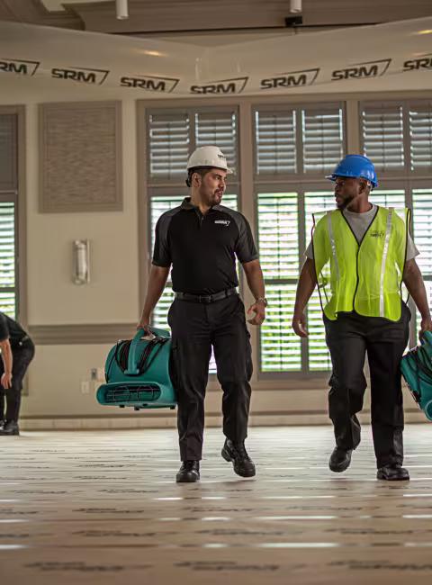 commercial water damage technicians carrying drying equipment