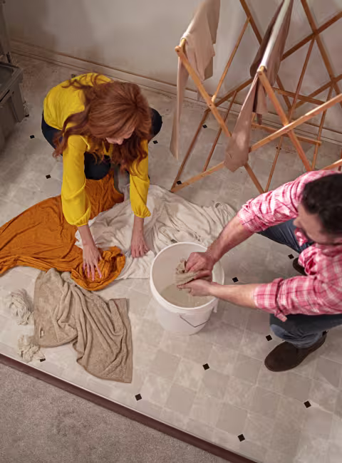 male and female cleaning water from basement floor 