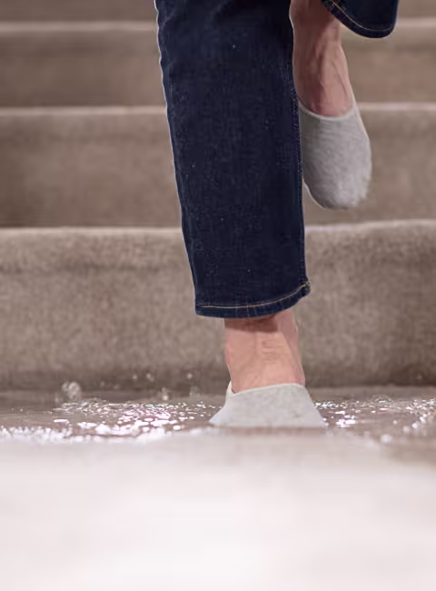 female stepping in puddle on carpeted floor
