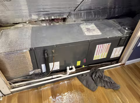 HVAC system leak with puddles on the wood floor