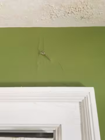 wall and ceiling paint peeling from water damage