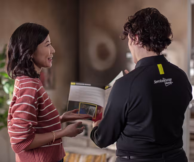 servicemaster restore technician discussing fire damage in a livingroom with a homeowner