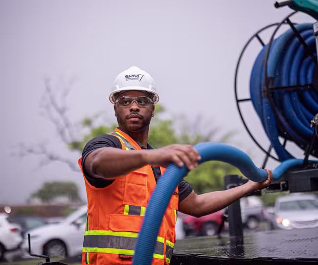servicemaster restore technician unrolling a truck mounted-water-extraction hose