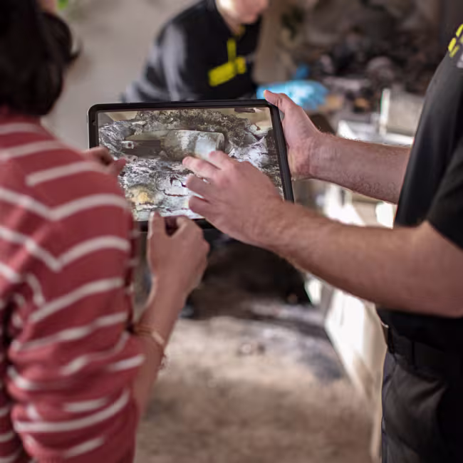 servicemaster tech and customer looking at fire damage on a tablet
