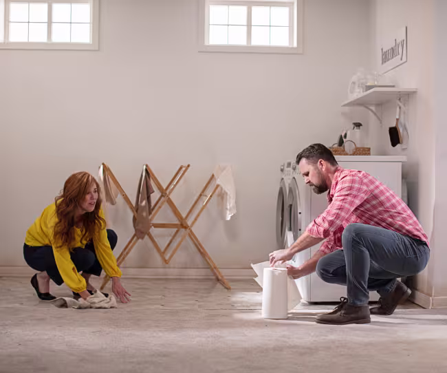 couple attempting to cleanup water in their flooded basement