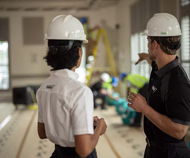 servicemaster restore technicians talking and pointing in a business
