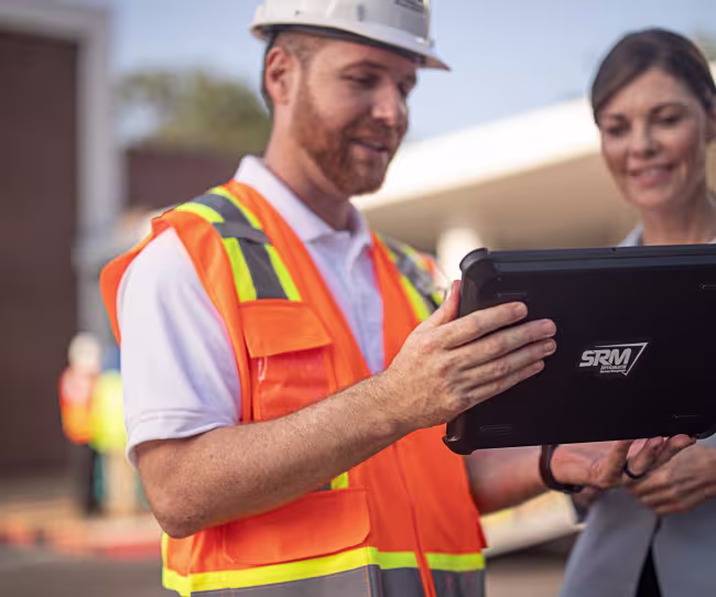 servicemaster-restore-technician-talking-with-a-business-looking-at-a-tablet