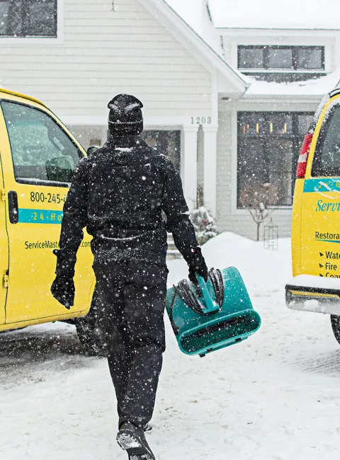ServiceMaster Restore vans and employee in the snow