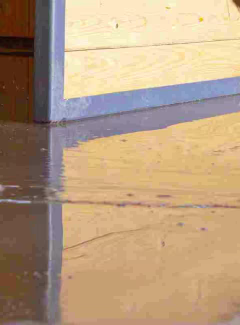 person cleaning up a flooded basement