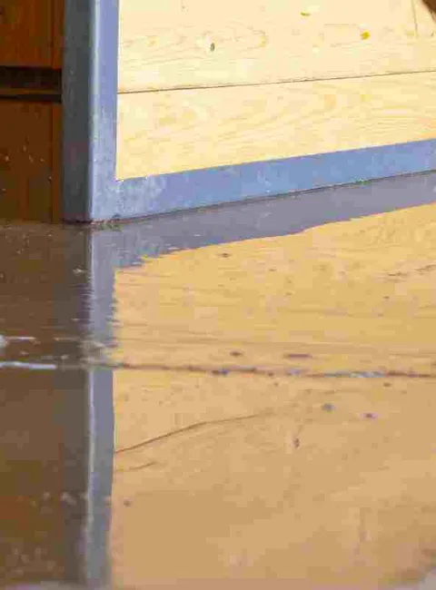 person cleaning up a flooded basement