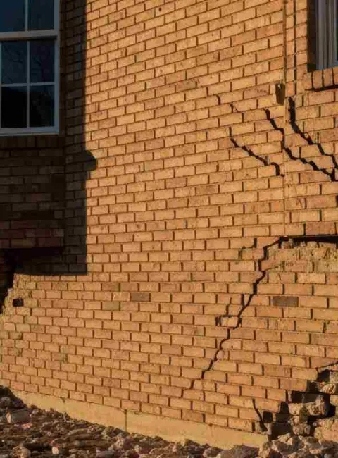 cracked brick on side of home due to water damage