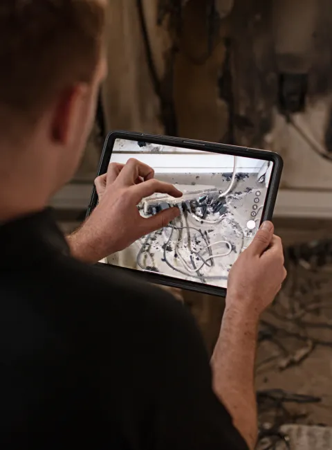 technician inspecting and documenting fire damage in home