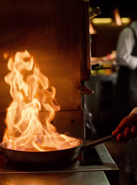 fire in cooking pan in commercial kitchen