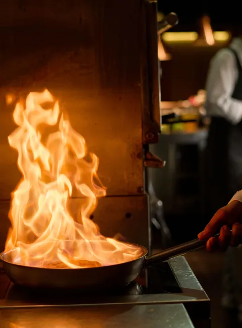 fire in cooking pan in commercial kitchen