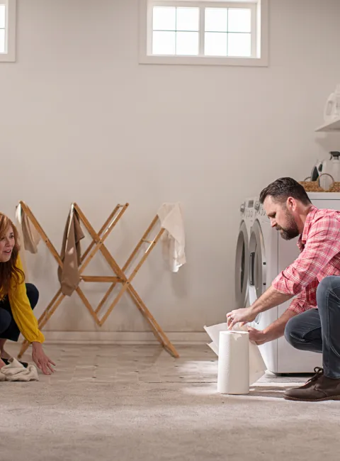 couple attempting to cleanup water in their flooded basement