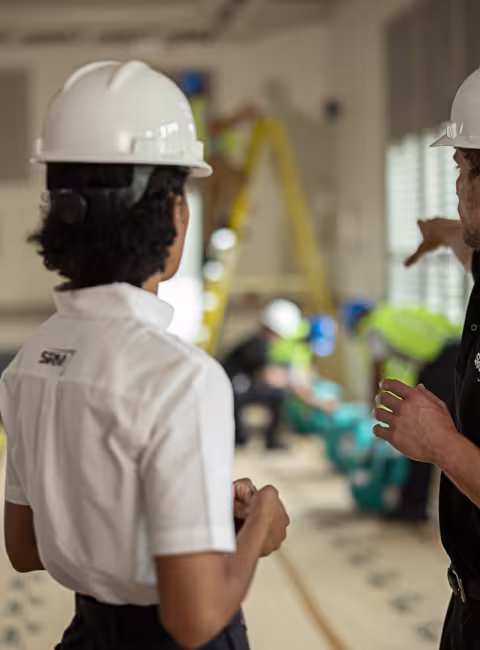 servicemaster restore technicians talking and pointing in a business