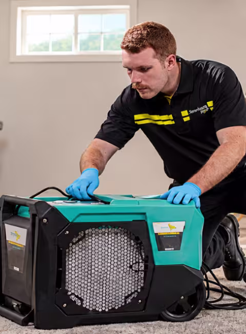 ServiceMaster Techs Setting Up drying equipment banner