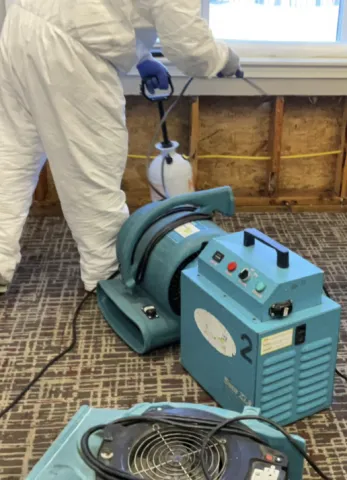 technician sanitizing area with drying equipment