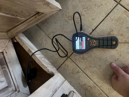Moisture meter being used in cabinet cavity to measure moisture content
