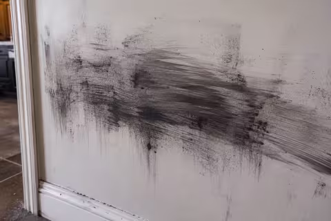 Close up of improperly cleaned soot smeared across painted drywall