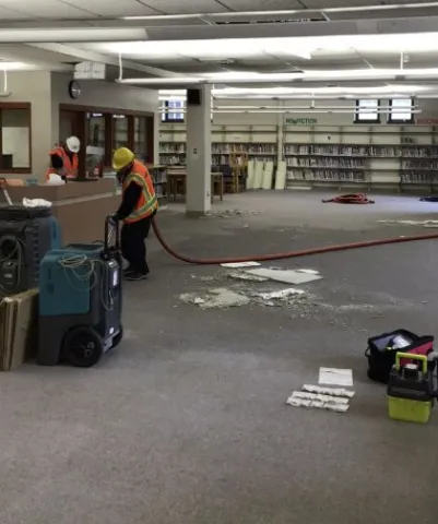 technician cleaning water damaged library