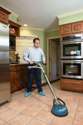 servicemaster technician cleaning tile floor