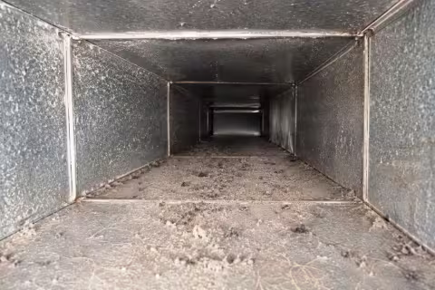 An interior view of a supply duct with moderate debris and soiling prior to cleaning