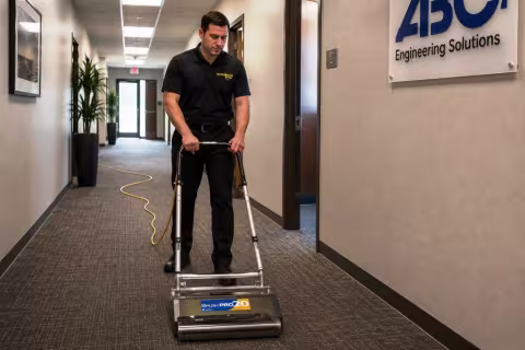 ServiceMaster Technician using a counter rotating brush machine to clean carpet with the very low moisture encapsulation process