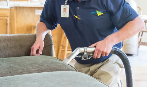 ServiceMaster technician cleaning a sofa using hot water extraction