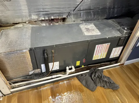 HVAC system leak with puddles on the wood floor