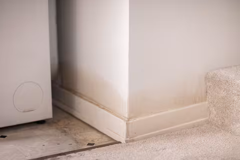 Discolored drywall and baseboard due to water damage