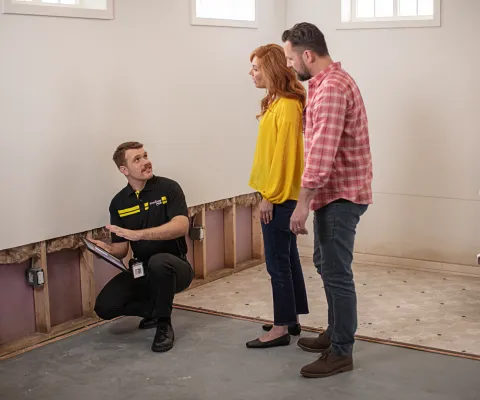 servicemaster restore technician discussing water damage restoration plan with homeowners