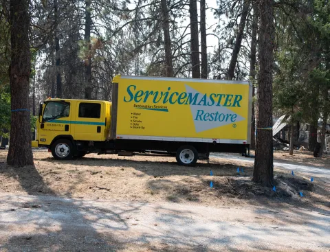 ServiceMaster Restore truck parked near fire-damaged property