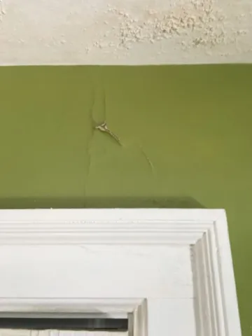 wall and ceiling paint peeling from water damage