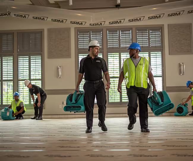 commercial water damage technicians carrying drying equipment
