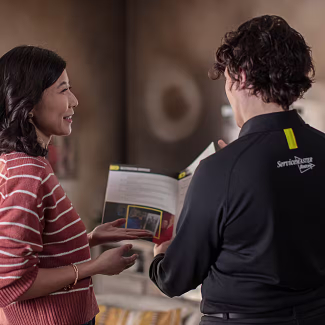 servicemaster technician and customer looking at fire damage repair options