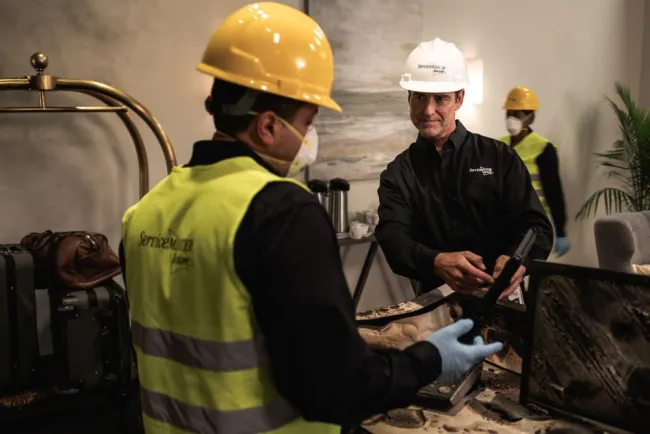 two-servicmeaster restore technicians discussing a job and planning restoration efforts