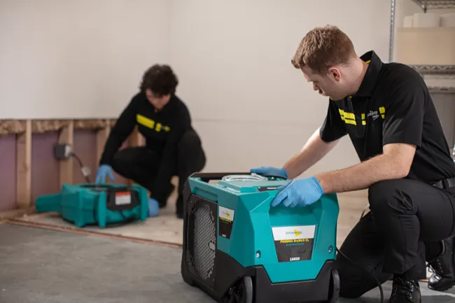 ServiceMaster Technicians setting up drying equipment