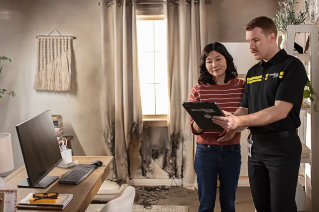 ServiceMaster technician consulting with homeowner post fire damage assessment