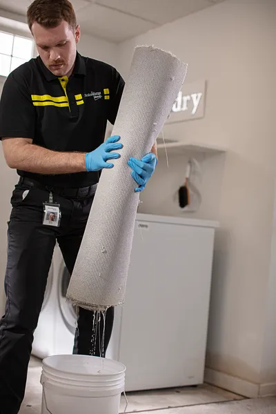 ServiceMaster tech removing wet carpet from basement