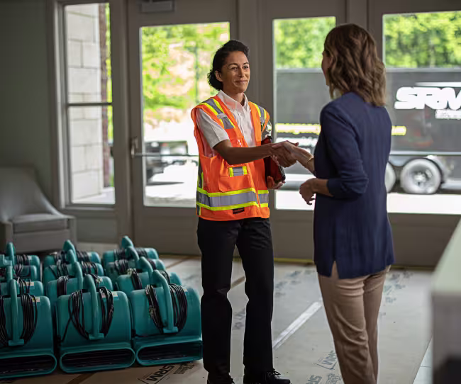servicemaster restore technician shaking hands with a business owner