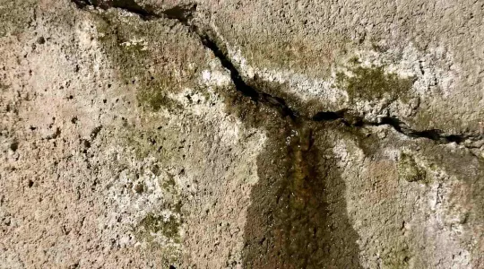 cracked foundation with water leaking through