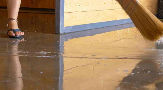 person cleaning up a flooded basement