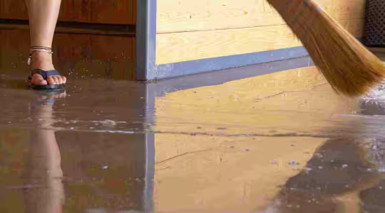 person cleaning up a flooded basement