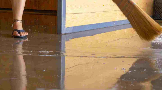 person cleaning up a flooded basement