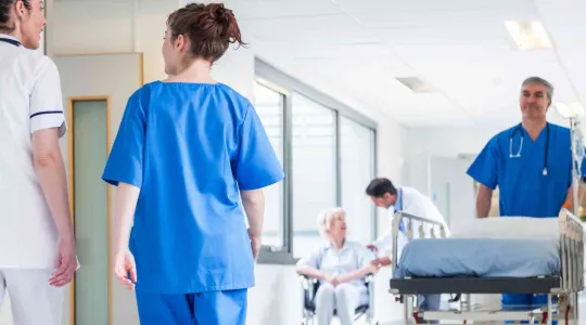 Hospital hallway with an pushing a hospital bed