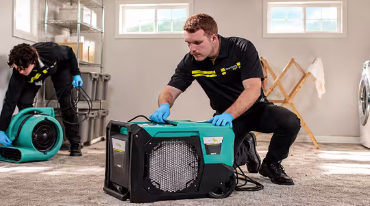 ServiceMaster Techs Setting Up drying equipment banner